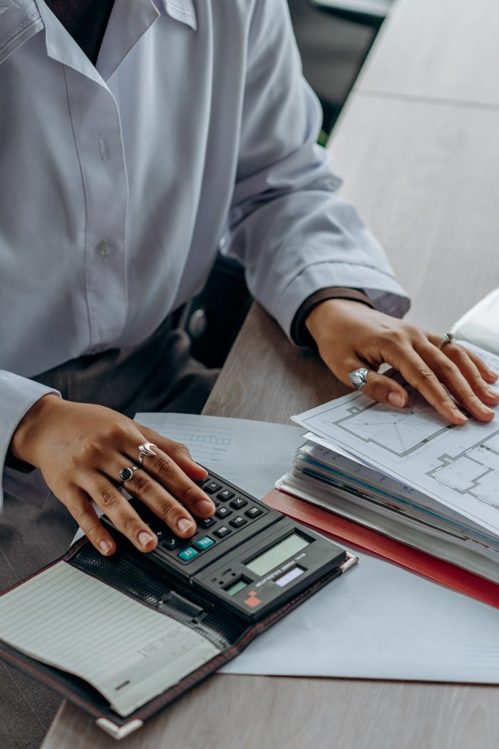 brand-02 Accountant calculates finances with a calculator and documents on a desk.